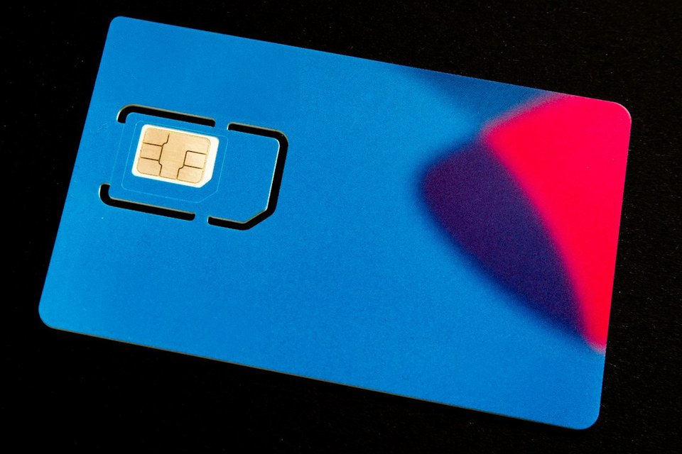 Kartu SIM fisik dengan chip emas di permukaan gelap